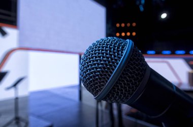 Sahne Alanı'nda dinamik bir mikrofon. Arka plandaki parlak spot ışığı.