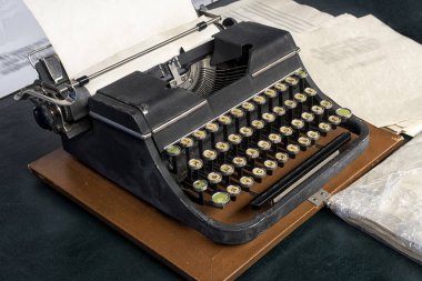 Eski vintage daktilo ve eklenen boş bir sayfaya.