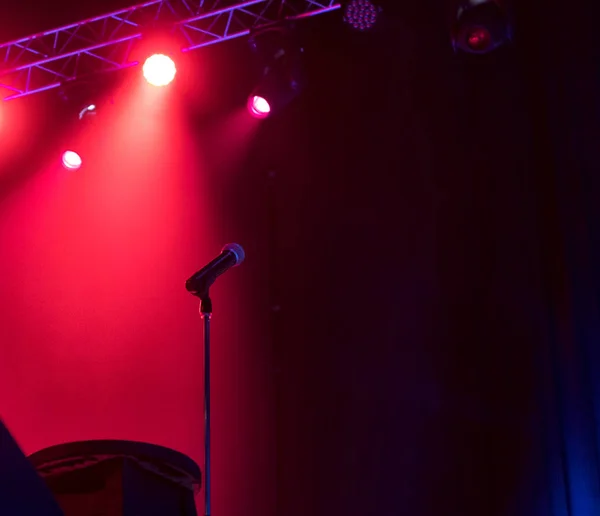 Micrófono en el escenario con luces de escenario en el fondo . — Foto de Stock