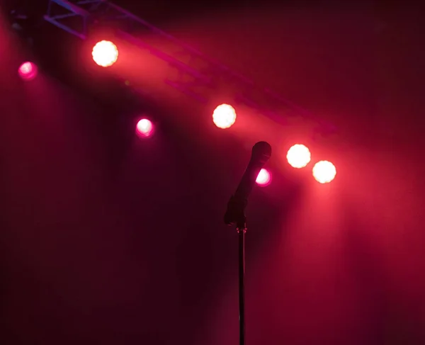 Micrófono en el escenario con luces de escenario en el fondo . — Foto de Stock