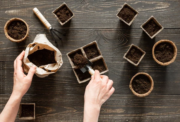 Femme verse terre dans les pots respectueux de l'environnement — Photo