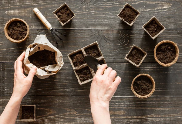 Femme verse terre dans les pots respectueux de l'environnement — Photo