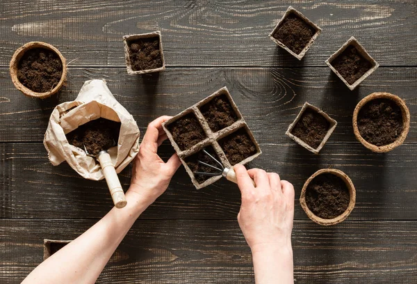 Femme verse terre dans les pots respectueux de l'environnement — Photo