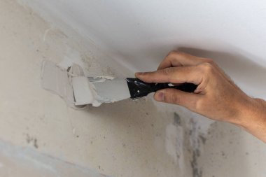 Bir spatula ve macun ile Işçi eli