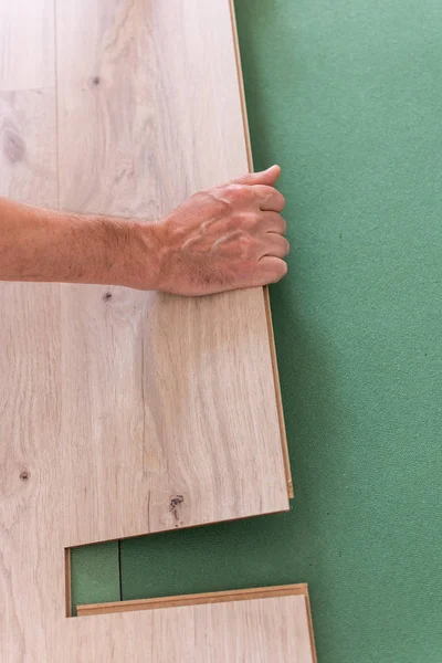 Worker installing wooden laminate flooring — Stock Photo, Image