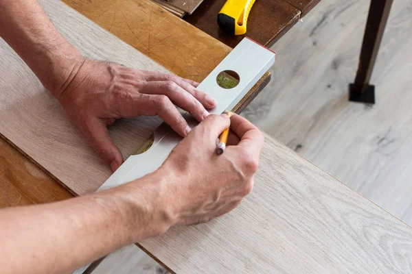 Worker marks the length of the laminate — Stock Photo, Image