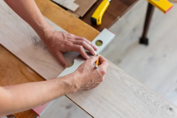 Worker marks the length of the laminate — Stock Photo, Image