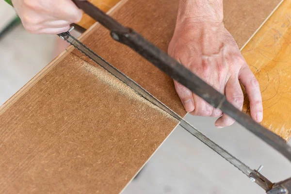 Worker cuts a laminate of a certain length — Stock Photo, Image