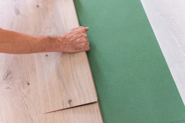Pracownik Instalowanie drewnianych podłóg laminowanych — Zdjęcie stockowe