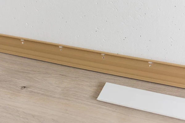 Installing plastic skirting board in the room