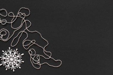 Siyah arkaplanda kar taneleri ve gümüş boncuklar