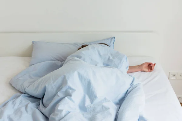 Frau schläft auf einem weißen Bett — Stockfoto