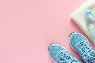Mavi spor ayakkabılar ve pembe arka planda su olan bir havlu, spor ya da spor yapmak, üst görüş, sağlıklı spor yaşam tarzı konsepti
