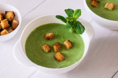 Lezzetli taze krema çorbası taze bezelye ve nane şekeri beyaz ekmekten yapılmış, sağlıklı yiyecek.