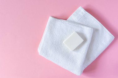 Pembe arka planda sabunlu beyaz havlu, banyo spa aksesuarları