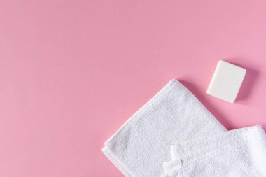 Pembe arka planda sabunlu beyaz havlu, banyo spa aksesuarları