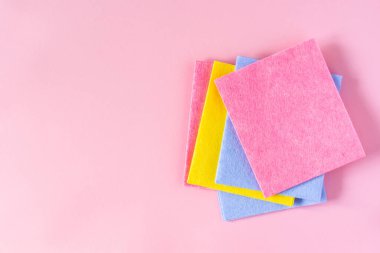 Pembe arka planda çok renkli giysiler, temizlik ve temizlik konsepti.