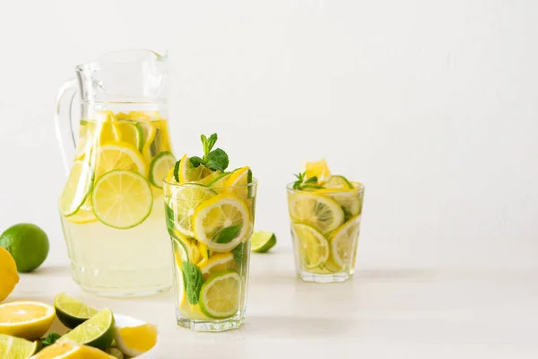 レモン ライム ミントの夏のさわやかな飲み物 レモネードとガラスと柑橘類のスライスとジャグ — ストック写真