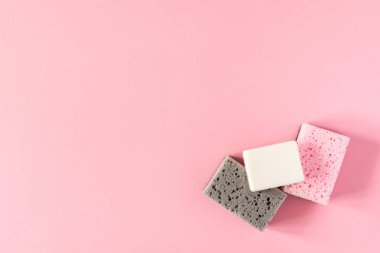 Pembe arka planda sabunlu çok renkli temizlik süngeri, temizlik ve temizlik konsepti.