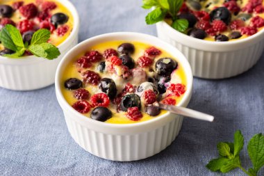 Beyaz yoğurt, böğürtlen, ahududu ve yaban mersininden yapılan enfes krakerler porsiyonlu kaseler halinde masada.