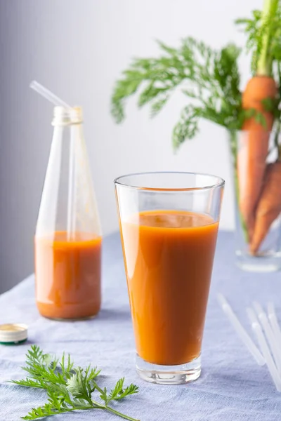 Natural carrot juice with pulp sugar-free in glasses on a table with a blue tablecloth