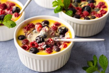 Beyaz yoğurt, böğürtlen, ahududu ve yaban mersininden yapılan enfes krakerler porsiyonlu kaseler halinde masada.