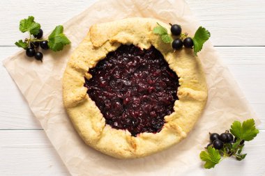 Siyah frenk üzümlü kısa hamurlu pasta, beyaz arka planda leziz bir jostaberry galette.