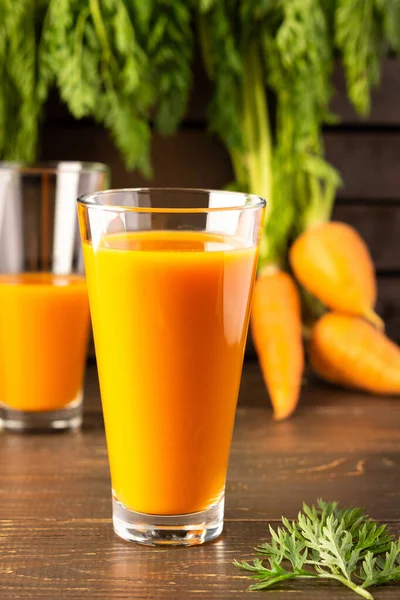 Natural carrot juice with pulp sugar-free in glasses on a wooden table