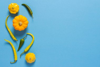 Taze kabak hasadı, sarı pattisonlar ve mavi arka planda biber.