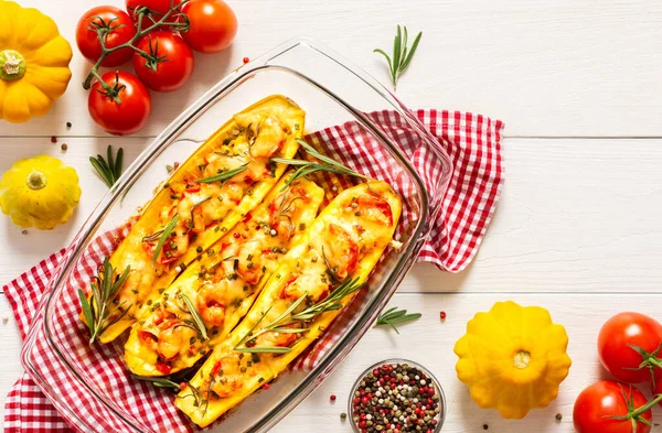Stewed yellow zucchini with tomatoes and onions, cheese and herbs, carrots and spices, stuffed zucchini on a white wooden background