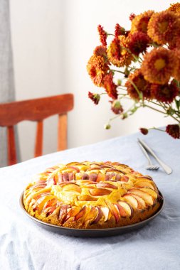 Lezzetli elmalı turta, ev içi, mavi masa örtülü masa, sonbahar çiçekli vazo kasımpatı.