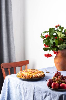 Lezzetli elmalı turta, ev içi, mavi masa örtülü masa, sonbahar çiçekli vazo kasımpatı.