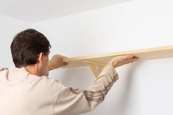 Man Hangs Shelf Apartment White Wall Worker Checks Evenness Shelf — Stock Photo, Image