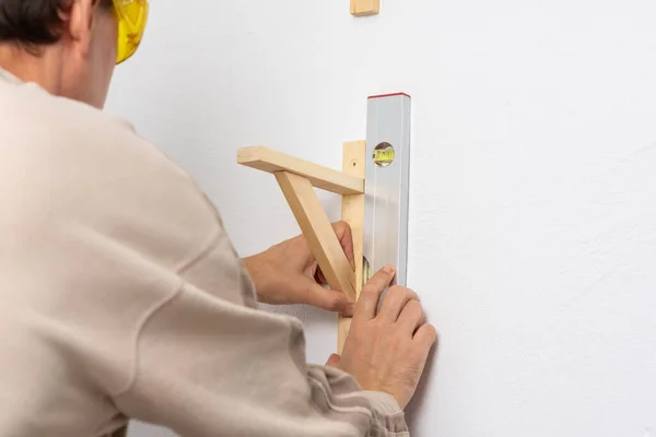 Man Hangs Shelf Apartment White Wall Worker Checks Evenness Shelf — Stock Photo, Image