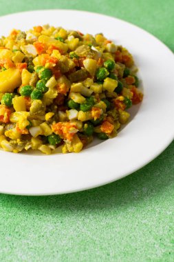 Kaynamış yumurta, taze tavuk göğsü ve patatesler, havuçlar ve yeşil bezelyeler gibi canlı sebzelerin hepsi besleyici bir yemek için bol zeytinyağı ile giydirilmiştir..