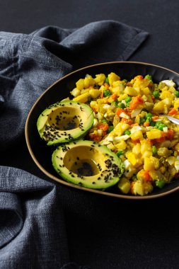 Sağlıklı salata haşlanmış yumurta, taze tavuk göğsü, doğranmış patates, canlı havuç, taze yeşil bezelye ve üzerine susam tohumu ve zeytin yağı serpilmiş kremalı avokado içerir.