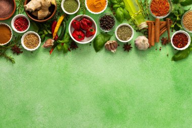 Taze, çok renkli baharat ve bitkilerden oluşan canlı bir karışım, narin yeşil bir arka planda, yemek pişirme ve aşçılık ilhamı için mükemmel, üst görünüm, kopyalama alanı