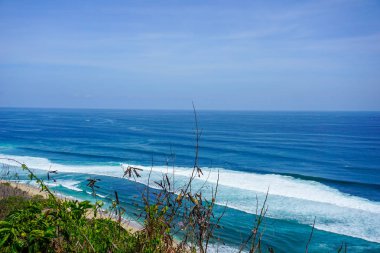Mavi gökyüzü ve dalgalar Bali Uluwatu Tapınağı plajüzerine çökmesini, Endonezya.