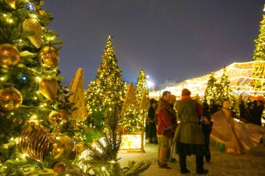 Moskova şehir merkezinde Kızıl Meydan'da Noel pazarında Insanlar, Noel için Dekore edilmiş ve ışıklı Kızıl Meydan