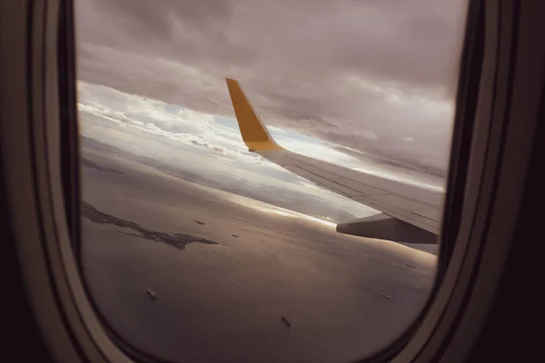 Vista aérea do céu azul e nuvem vista através da janela de uma aeronave, asa de avião da janela . — Fotografia de Stock