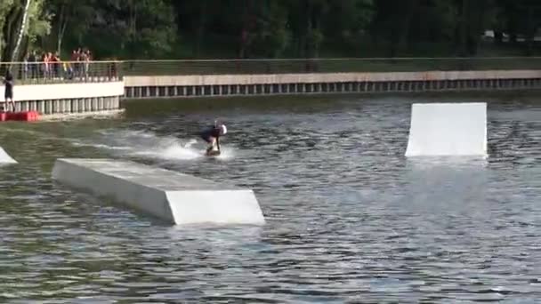 Petit garçon chevauchant un wakeboard dans le parc — Video