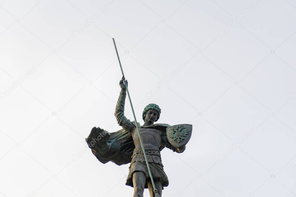 The statue of an angel pointing down with the tip of a spear