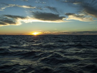 Beyaz renkli bulut mavi gökyüzü gündoğumu deniz okyanus su su yansımaları ile üzerinde manzarası