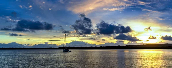 Altın ve mavi deniz panoramik gündoğumu deniz manzarası üzerinde su yansımaları ile deniz suyu. Queensland, Avustralya.