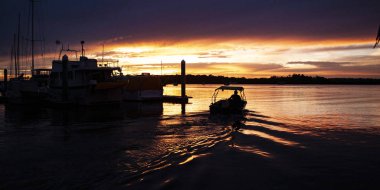 Bir muhteşem ilham parlak renkli Stratus bulut deniz suyu siluetleri okyanus su yansımaları ile featuring tropikal panoramik günbatımı deniz manzarası. Teneke kutu Bay Marina, Queensland, Avustralya.