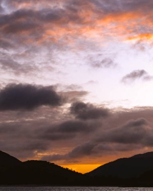 Parlak bir atmosferik bulutlu portakal kömür gökyüzü günbatımı görüntüyü su ve tanınmış kümülüs bulut üzerinden konut gök. Avustralya doğanın güzel doğal olay. 