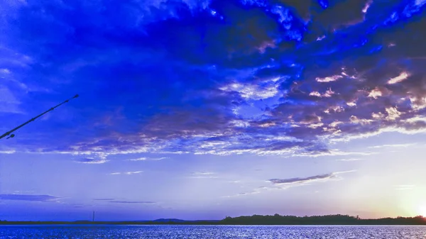 An eye catching inspirational blue skyscape sunset wih predominantly cumulus cloud, in a cobalt blue coloured sky. Seascape with ocean water reflections. Southern Hemisphere, Australia.