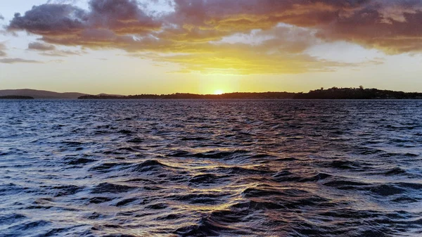 オーストラリアの夏の海 主に積雲雲 輝く沿岸海洋水の反映 薄い鋼青い空を背景に黄金の海の夕日 クイーンズランド州 オーストラリア — ストック写真