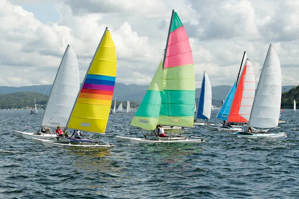 Dzieci żeglarskie małe żaglówki z kolorowymi żaglami na śródlądowych drogach wodnych. — Zdjęcie stockowe