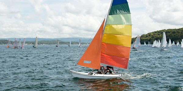 Carreras de niños navegando un pequeño catamarán velero con colorfu — Foto de Stock